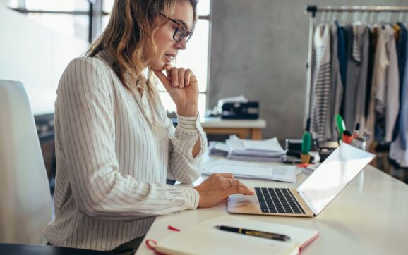 Właścicielka małej firmy analizująca reklamy Facebook i Instagram przy laptopie